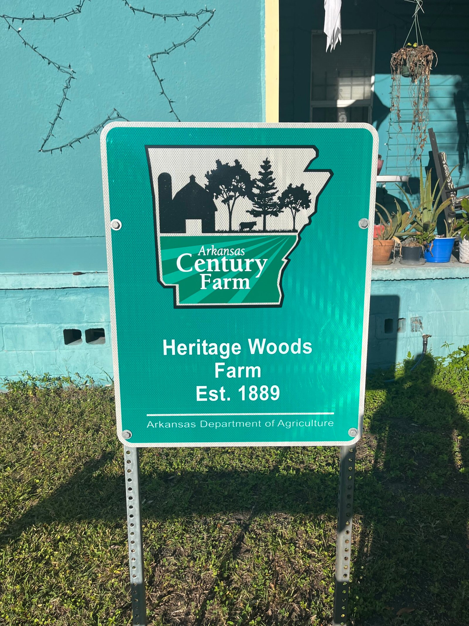 Farm sign reading Arkansas Century Farm, Heritage Woods Farm Est. 1889